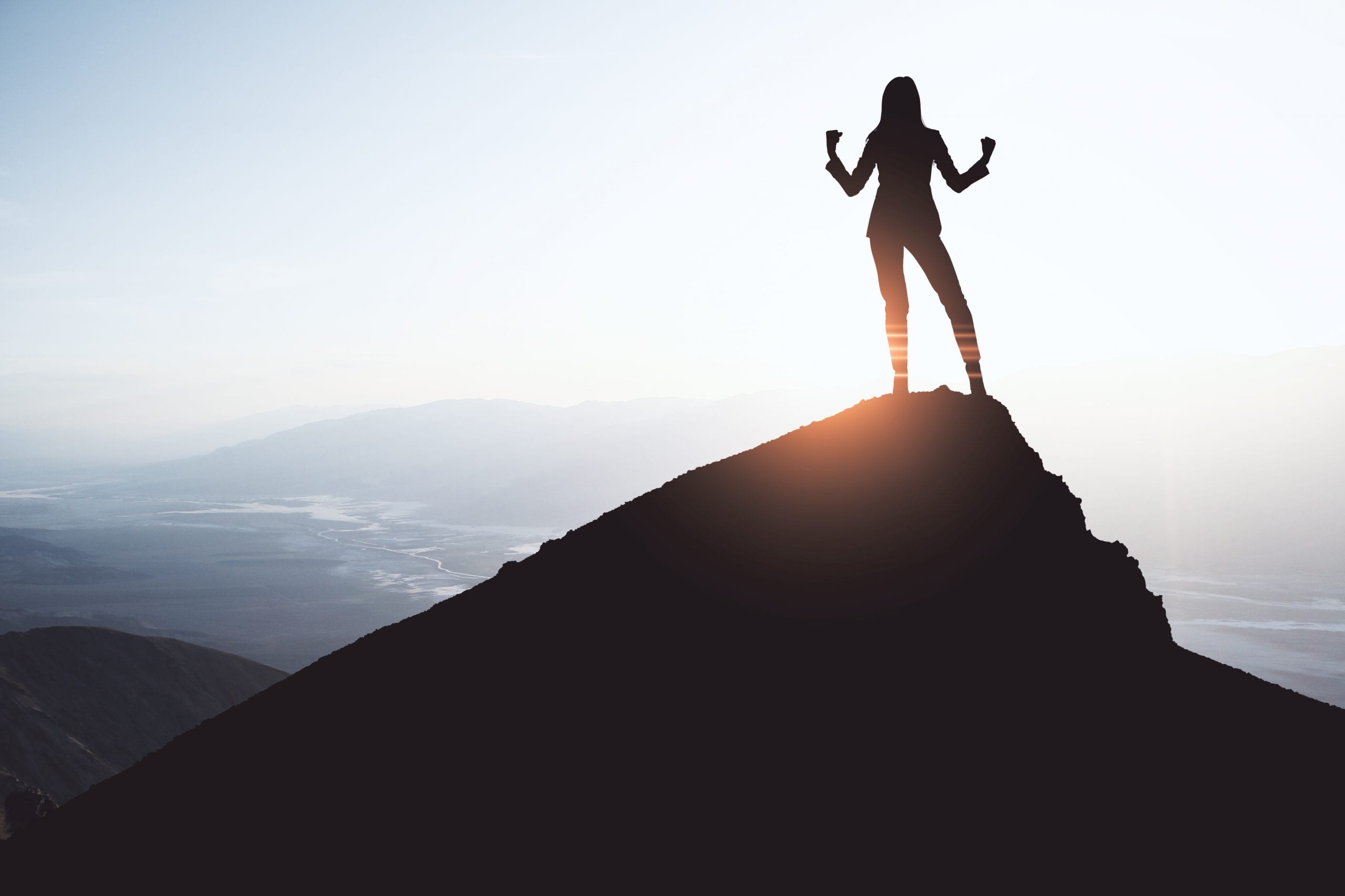 Happy businesswoman on cliff